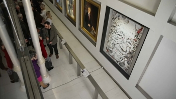 Imagem de Pantónio e João Amado com obras expostas nas paredes da Sala do Conselho de Estado